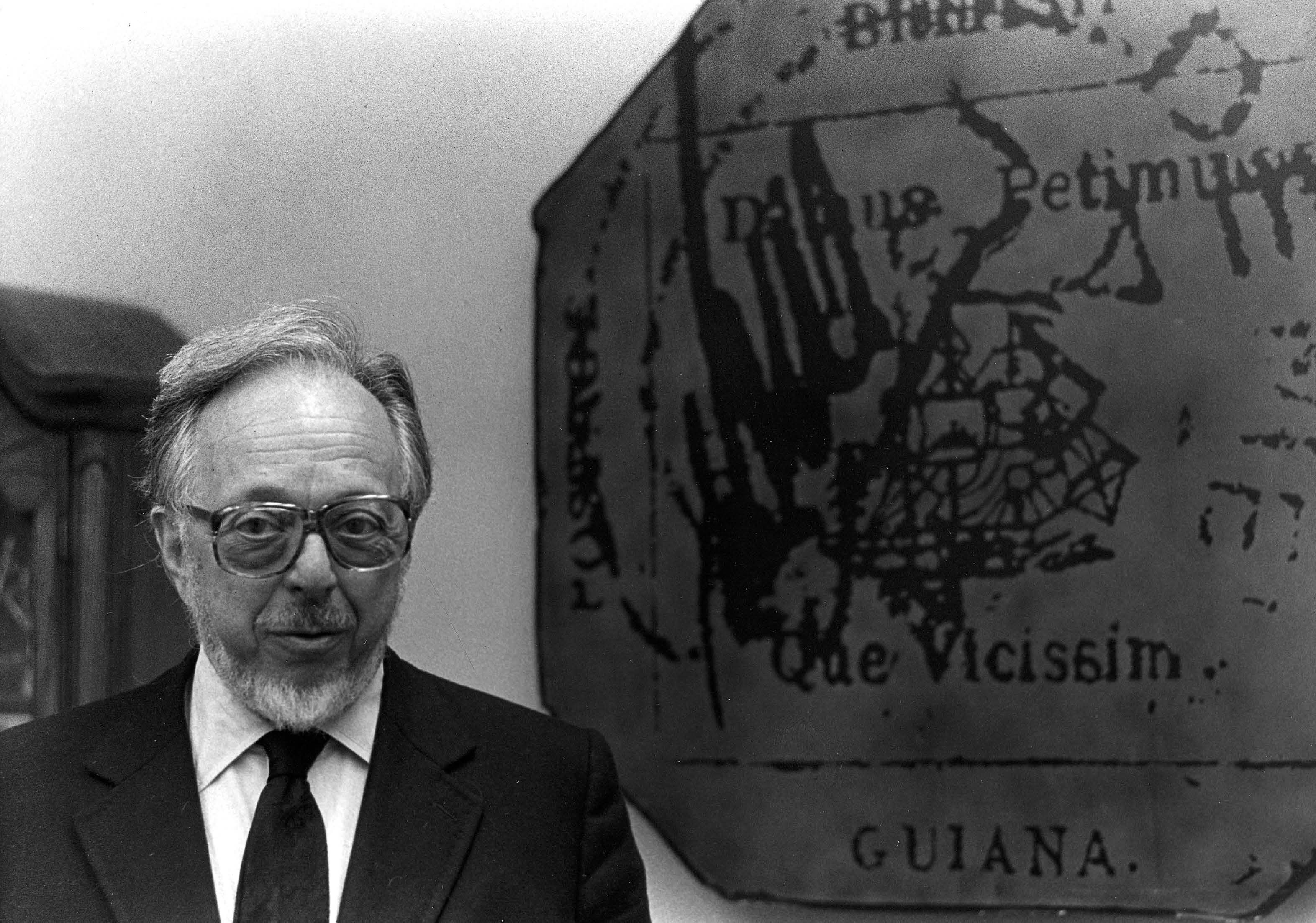 Robert A. Siegel photographed next to the British Guiana wall display — Siegel Auction Galleries